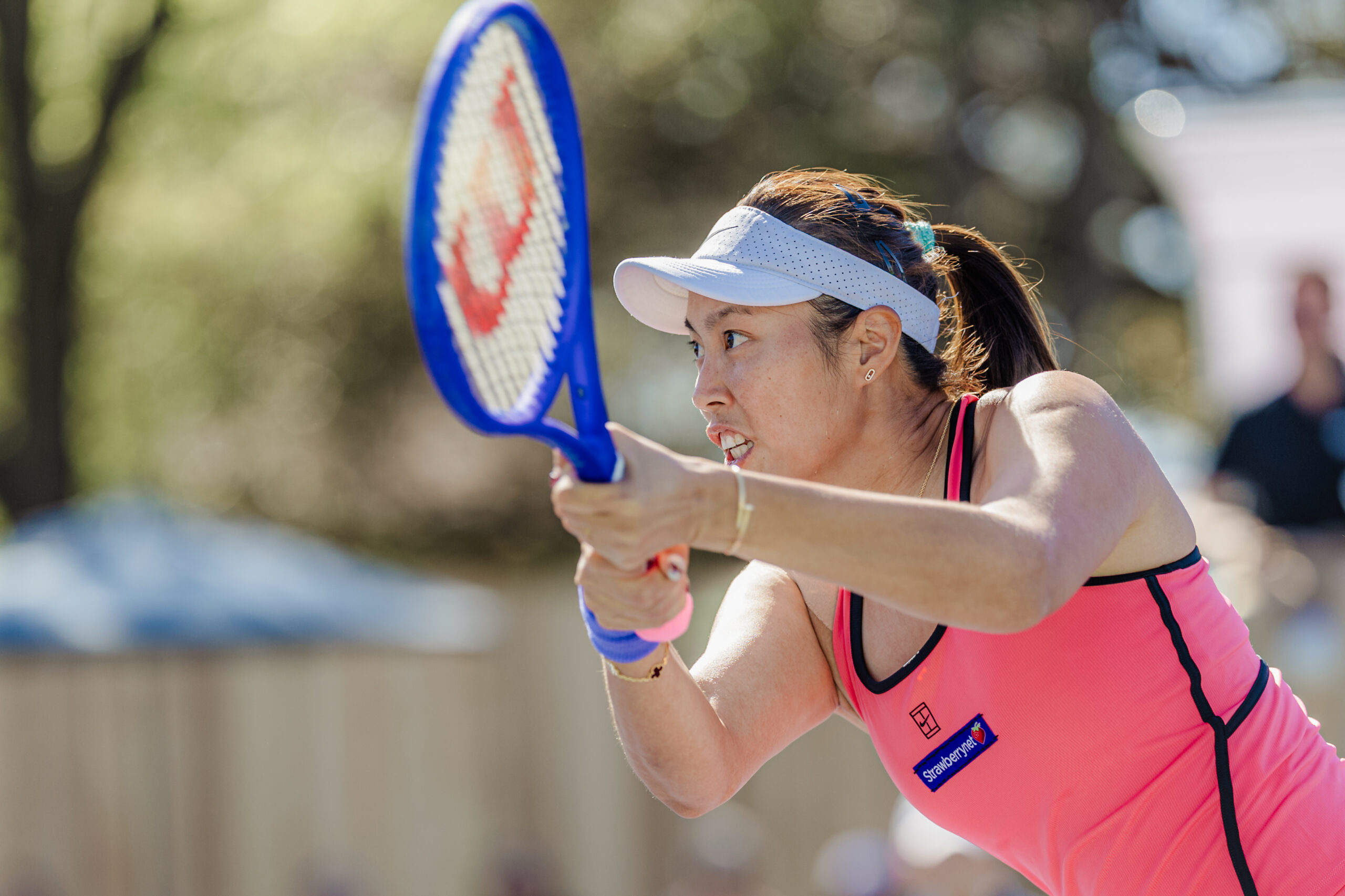 Hao-Ching Chan grimaces while hitting a forehand during a doubles match.
